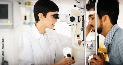 Fototapeta Naklejka Na Ścianę i Meble -  Woman doing eye test with optometrist in eye sight clinic