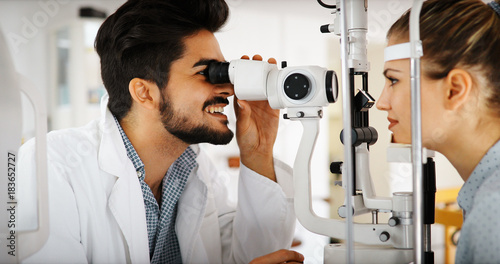 Patient or customer at slit lamp at optometrist or optician photo