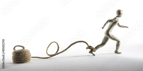 Man runs with a rope tied to the foot. Metaphor of hope. Isolated on white background. With copy space text. Studio Shot.