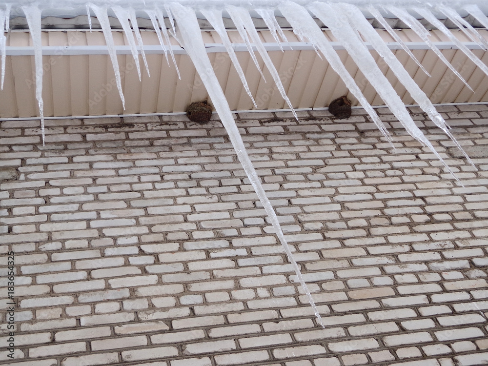 Icicles on the roof of the brick house