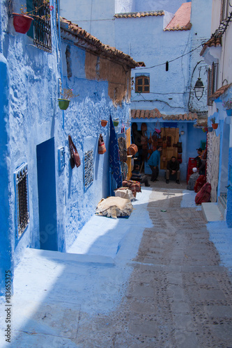 Traditional moroccan courtyard in Chefchaouen blue city medina in Morocco, architectural details in Blue town Chaouen. Typical blue walls and colorful flower pots. © sefoma