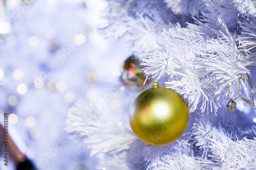 White Christmas tree background and close up golden ball decorations with light blurred. Happy New Year and Xmas theme