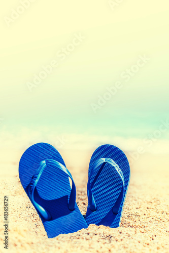 Summer Holidays in Beach Seashore. Summer vacation concept in vintage hipster style with blue flip flops.