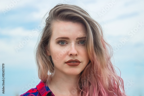 Fashion portrait of young hipster women with colorful hair and big red lips. Summer concept, sandy beach, bright sky and sea. Tourism, travel, holidays. © Kanturu