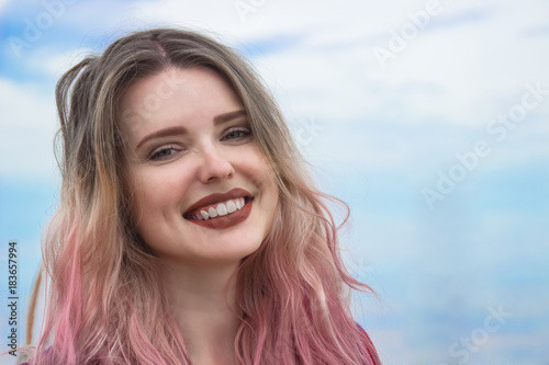 Fashion portrait of young hipster women with beautiful smile. Summer concept, sandy beach, bright sky and sea. Tourism, travel, holidays.