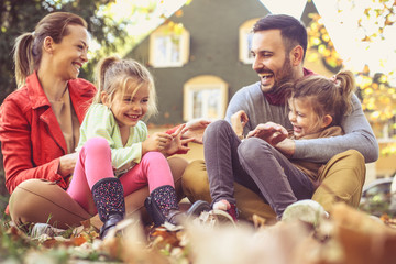 Little girls have fun with parents at backyard.