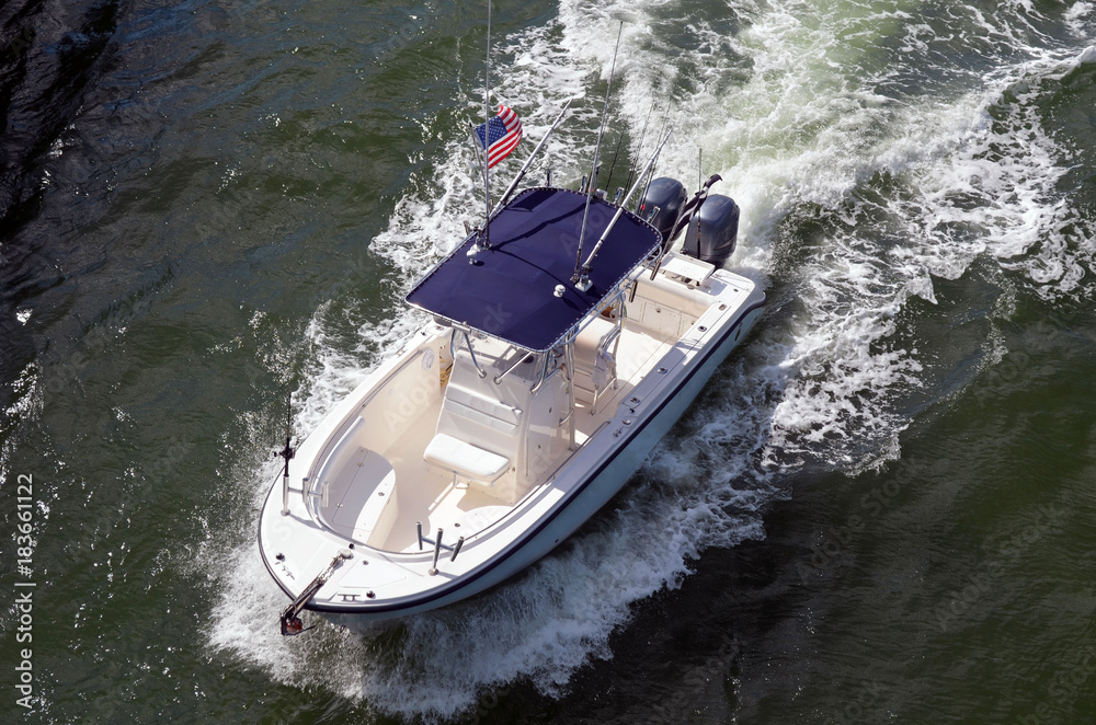 Angled over head view of a sorts fishing boat powered by two outboard engines.