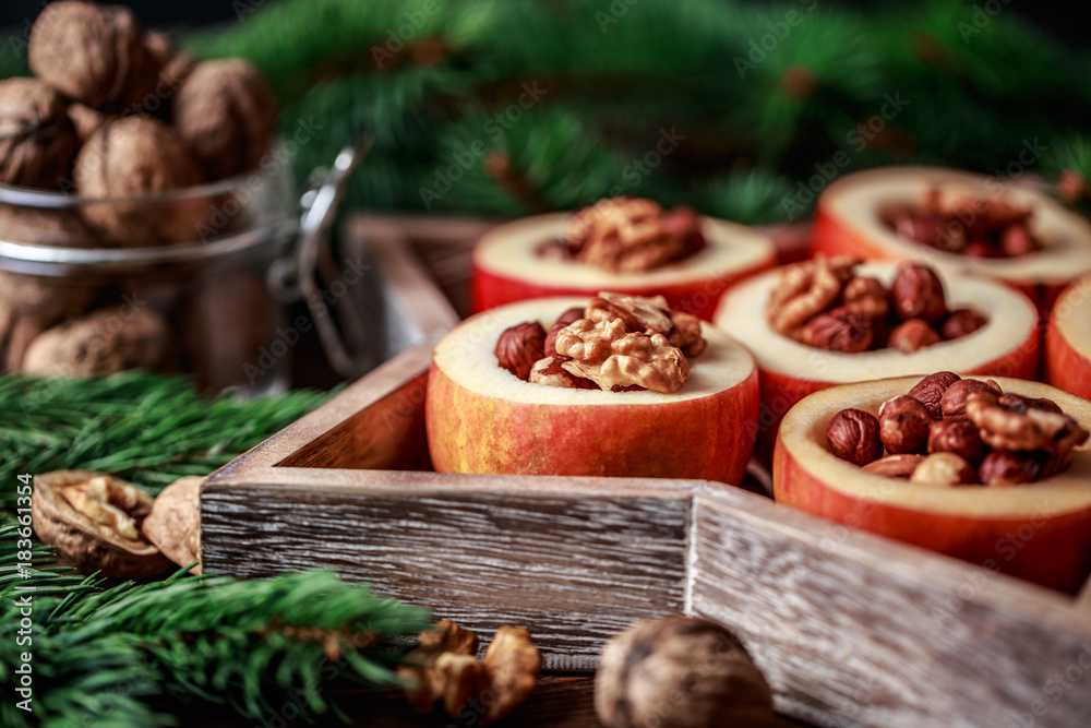 Baked apples with cinnamon on rustic background. Autumn or winter dessert. Closeup photo of a tasty baked apples with christmas decoration