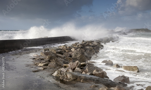 furious strong stormy waves near a concrete dam coastline in France