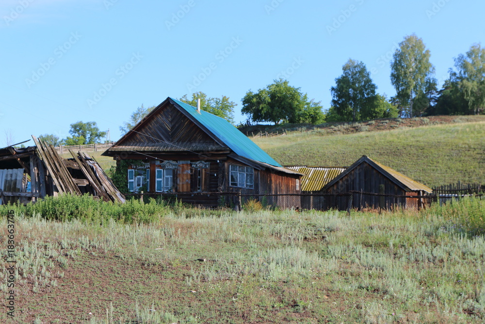Very old wooden house in the remote Russian village in the summer against a blue sky Very old wooden house in the remote Russian village in the summer against a blue sky