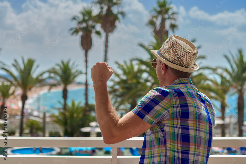 Fototapeta premium Man in sunhat watching at amazing sea view.