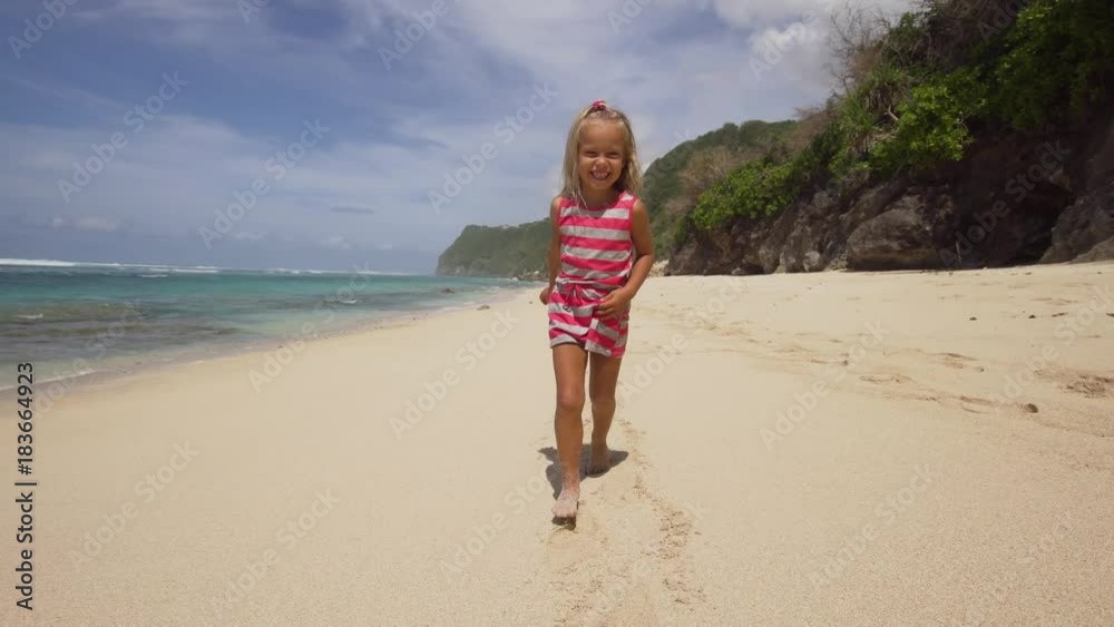 Little, pretty girl runs along a tropical beach of the sea and have fun. Cute happy girl has fun on vacation at sea. Bali,Indonesia. Travel concept. Little, pretty girl runs along a tropical beach of the sea and have fun. Cute happy girl has fun on vacation at sea. Bali,Indonesia. Travel concept.