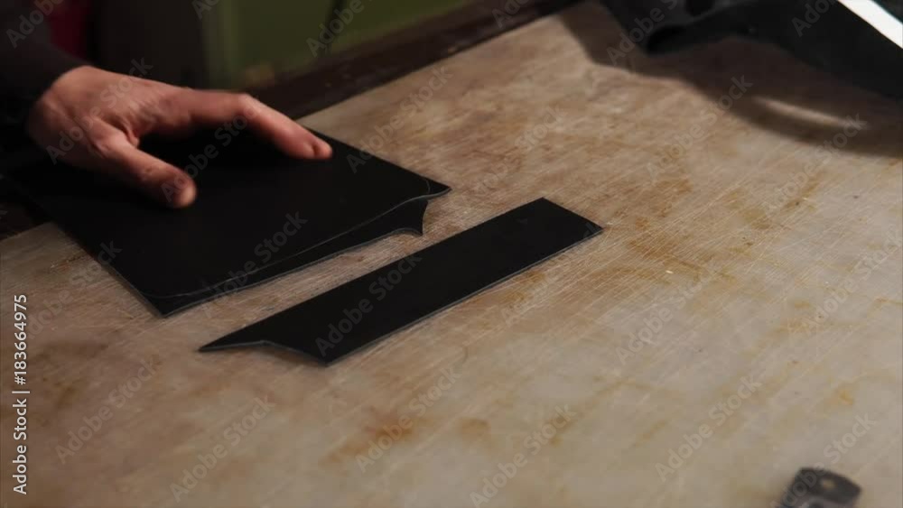 close up shot of the master of the hand, who cuts off excess fabric, the man holds a knife and ruler in his hand to make the product even close up shot of the master of the hand, who cuts off excess fabric, the man holds a knife and ruler in his hand to make the product even
