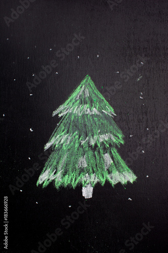 Christmas tree silhouette chalked on a blackboard. New year minimalism concept. photo