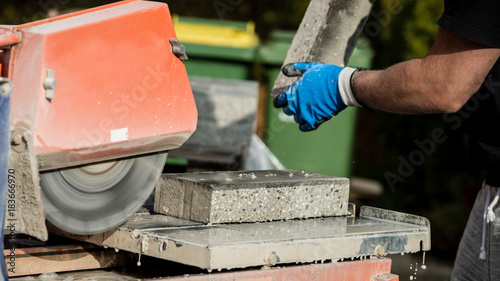 Building contractor working with a concrete block and an angle grinder