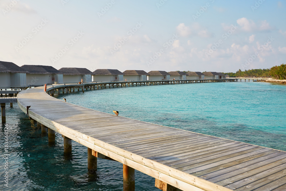 Water bungalows in hotel on Maldives. Villas on Indian ocean at luxury spa resort.