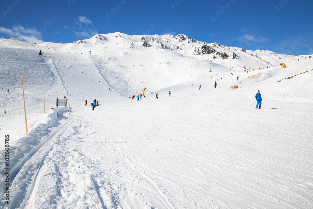 People skiing on prepared slopes covered by fresh snow in Tyrolian Alps, Zillertal, Austria, Europe