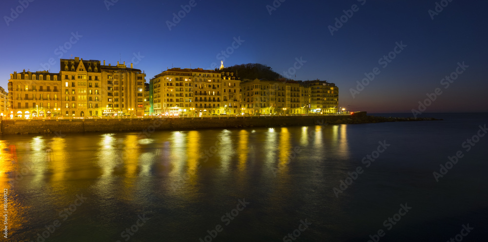 The lights of the city of San Sebastian are reflected in the sea water at night