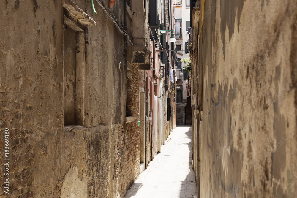 View of a narrow street with old, historical buildings in Venice