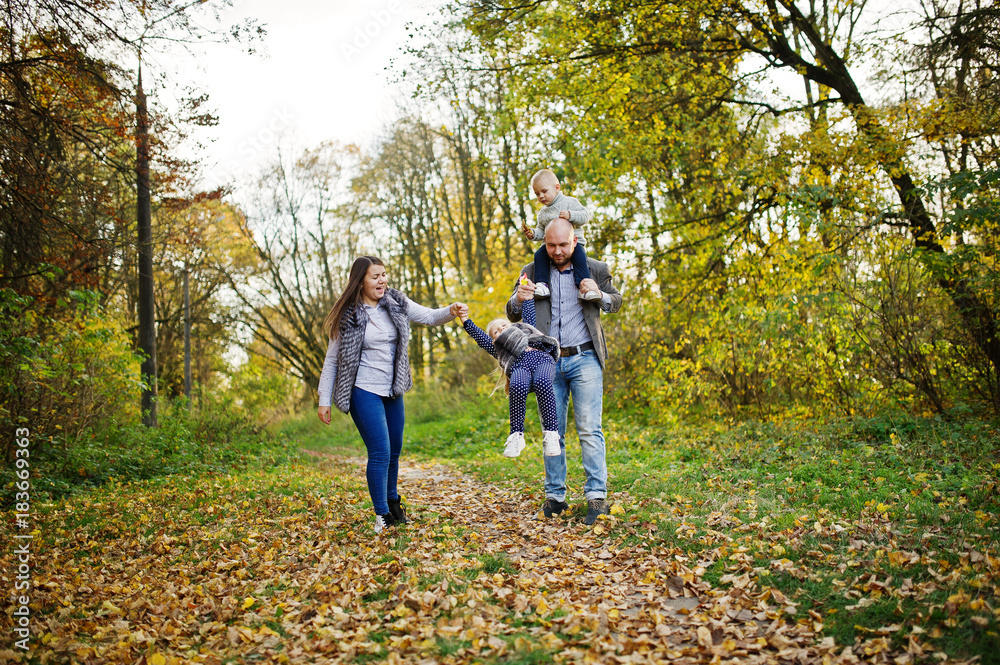 Happy caucasian family of mom dad and little girl with boy at majestic autumn fall forest. Happy caucasian family of mom dad and little girl with boy at majestic autumn fall forest.
