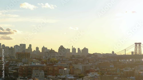 A real time shot of Williamsburg neighbourhood, Williamsburg Bridge and the view on Manhattan at sunset in New York City. Camera is turning right toward Downtown Manhattan. photo