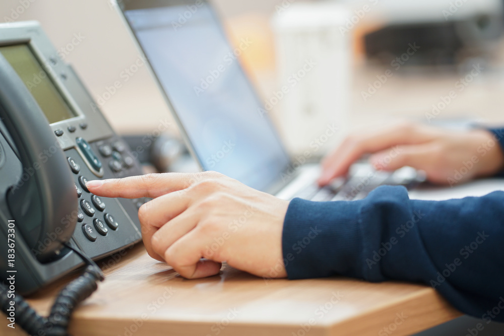 close up employee man hand press number on telephone for contact with someone , technology concept close up employee man hand press number on telephone for contact with someone , technology concept