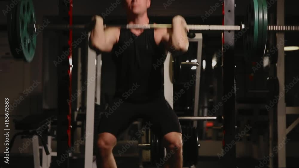 Young muscular man at the gym performing squats. Young muscular man at the gym performing squats.