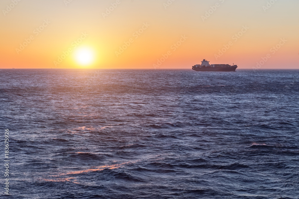 Large freight tanker at sunset in sea.