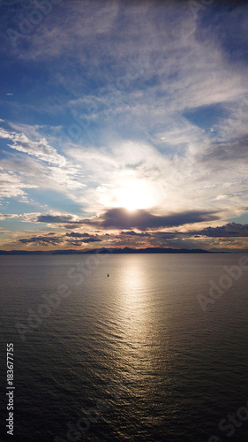Fototapeta Naklejka Na Ścianę i Meble -  Aerial drone bird's eye view of sunset in famous coast of Voula with beautiful scattered clouds, Athens riviera, Attica, Greece