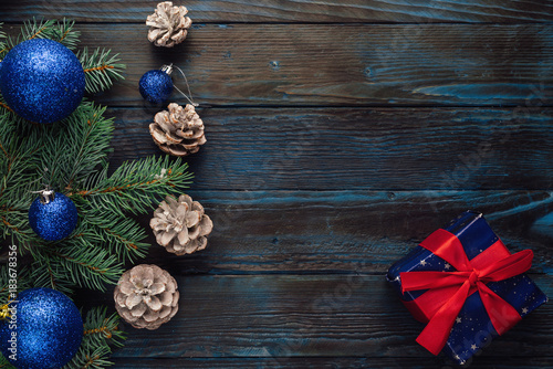 Christmas and Christmas decorations Pine branches of a tree, cones, blue Christmas toys on a wooden background.primary packaging