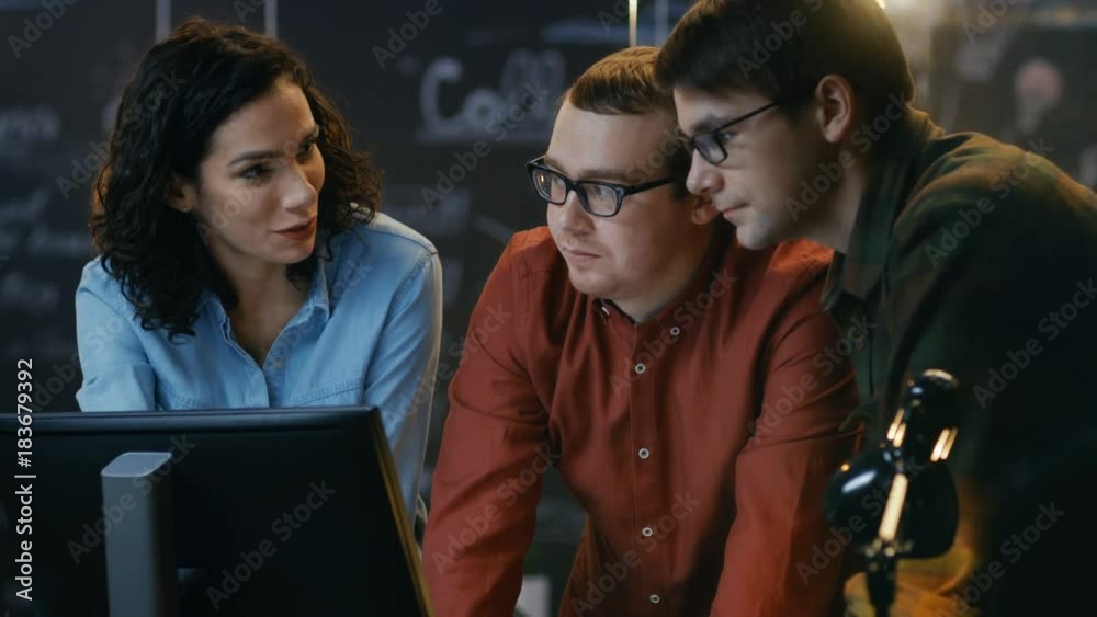 Three Office Employees Have Discussion about Ongoing Project, They Point at Personal Computer Screen. They Work in the Creative Office. RED EPIC-W 8K Camera. Three Office Employees Have Discussion about Ongoing Project, They Point at Personal Computer Screen. They Work in the Creative Office. RED EPIC-W 8K Camera.