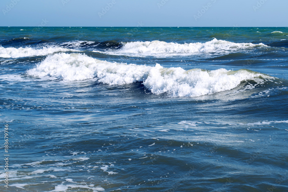 Blue waves on a sea beach on a sunny day