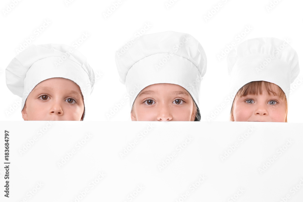 Cute children in chef's hats holding blank poster on white background Cute children in chef's hats holding blank poster on white background