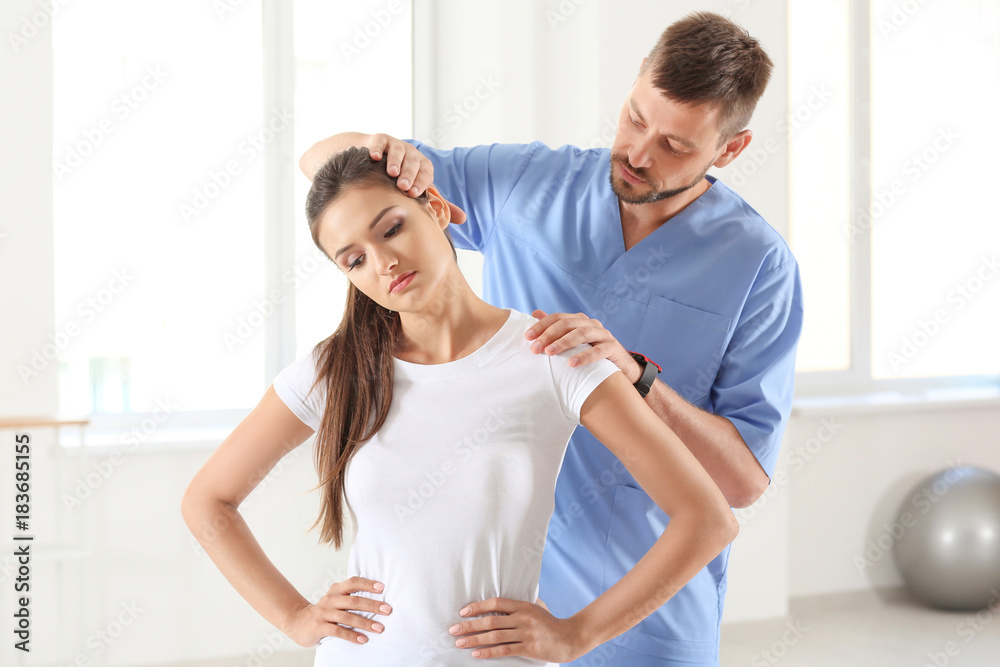 Fototapeta premium Physiotherapist working with young female patient in clinic