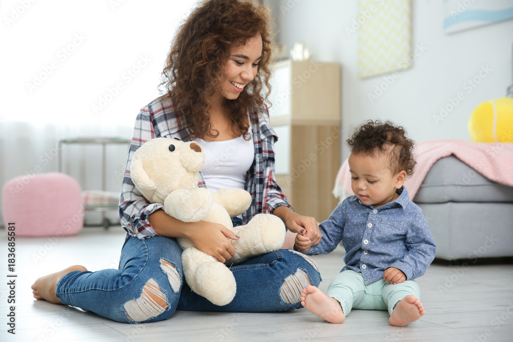 Cute baby and mother sitting on floor at home Cute baby and mother sitting on floor at home