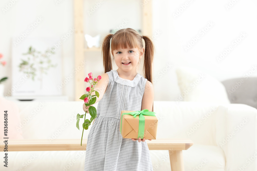 Little girl holding gift box and flower for Mother's day at home Little girl holding gift box and flower for Mother's day at home