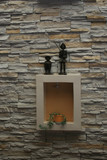 figurines and plant box inset to layered stone wall of restaurant Cotacachi Ecuador