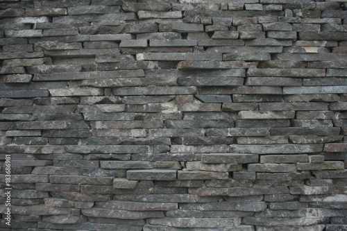 Wall of layered stone with textures of hewn stone 