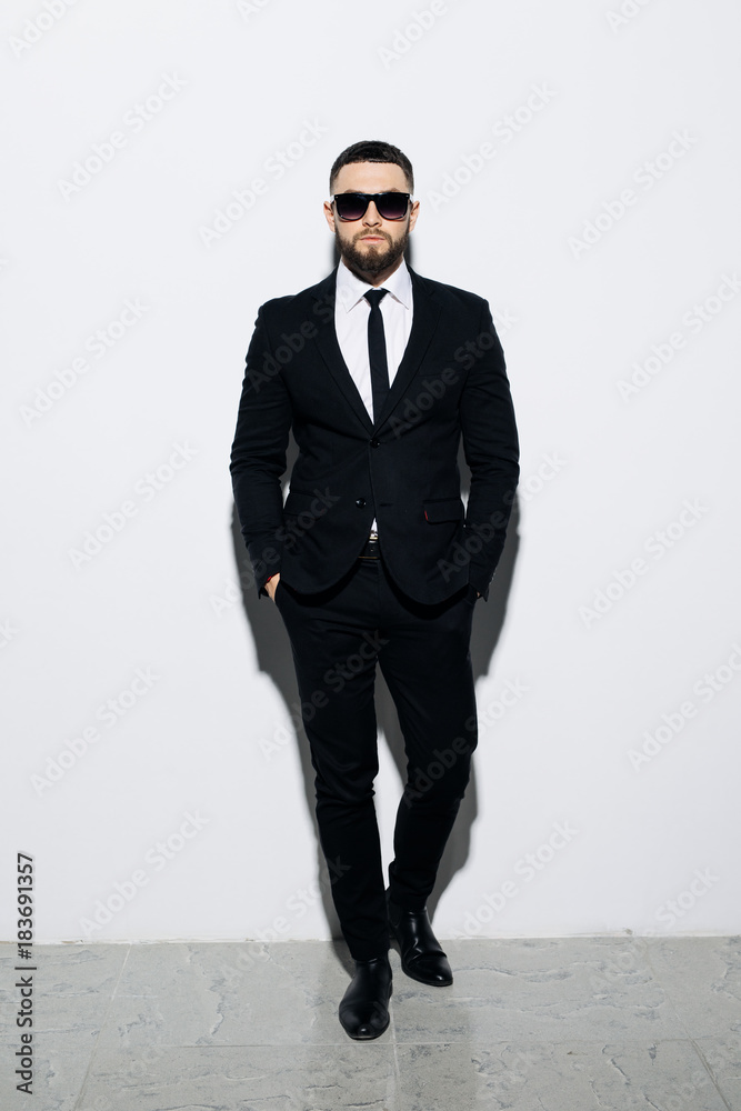 Men in full suit. Full length of confident young businessmen in sunglasses standing isolated on grey Men in full suit. Full length of confident young businessmen in sunglasses standing isolated on grey