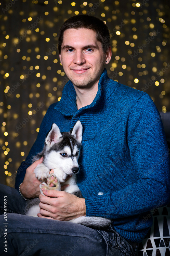 Obraz premium man in a Christmas atmosphere with a Husky puppy