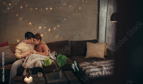 Tableau sur toile Couple relaxing on couch in hygge house