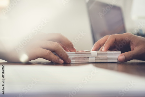 Close up of businessman hand giving money, Russian banknotes, to his partner on the table