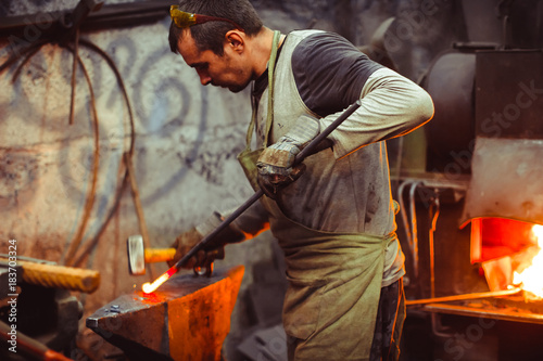 blacksmith working on an anvil © venerala