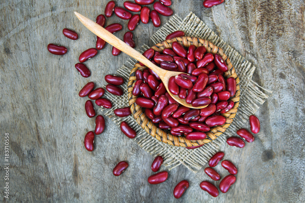 Red kidney bean on rattan cup on wooden background