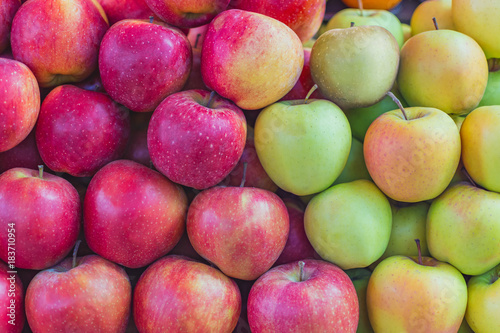 background texture of multi-colored apples stacked on the market counter
