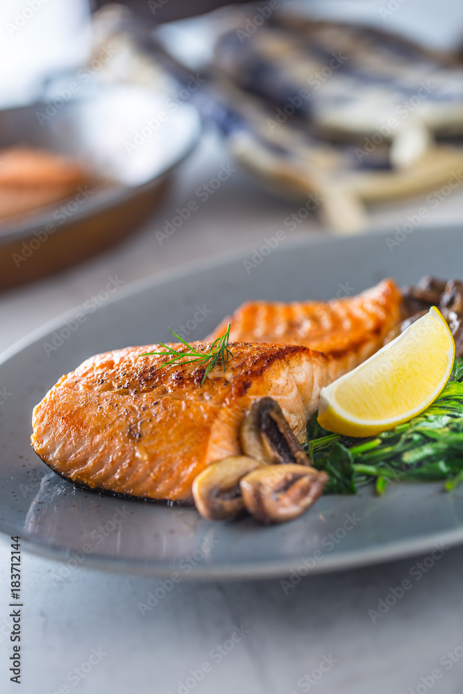 Salmon Roast Fillet. Portion of roast salmon fillet with spinach mushrooms in restaurant pub home or hotel Salmon Roast Fillet. Portion of roast salmon fillet with spinach mushrooms in restaurant pub home or hotel