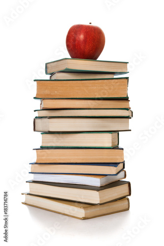 Book tower with a red apple isolated on white