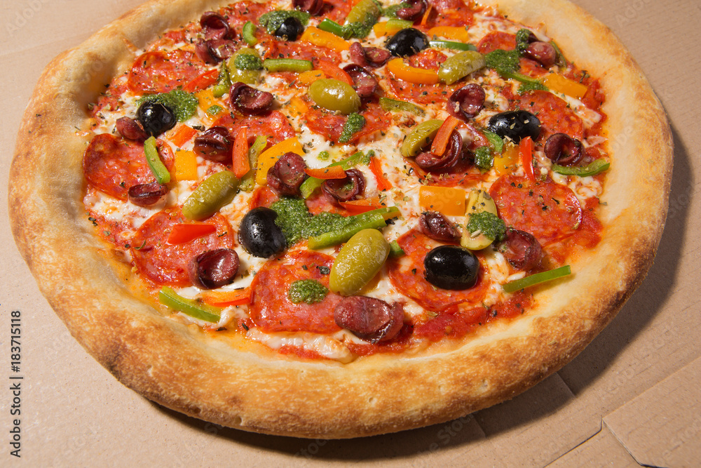 Italian pizza on a cardboard box, photo on a wide-angle lens Italian pizza on a cardboard box, photo on a wide-angle lens