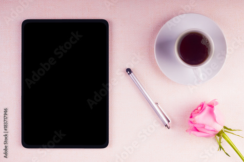 Tablet with a stylus and a cup of coffee with a rose on a light background - mock-up
