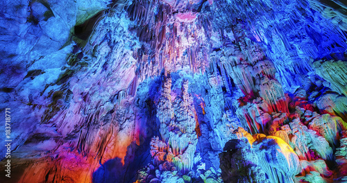 The Reed Flute Cave, natural abstract background. Limestone cave with multicolored lighting in Guilin, Guangxi, China.
